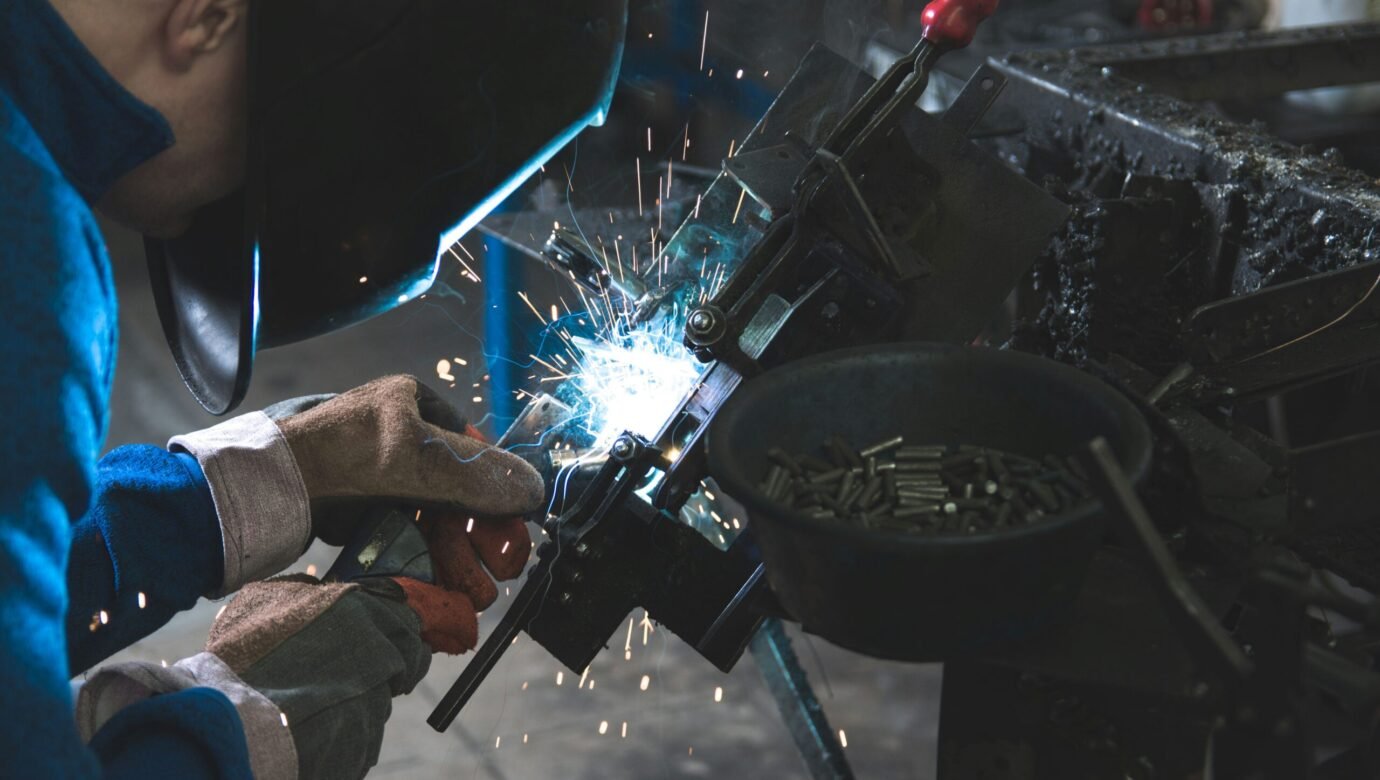 man welding a black metal