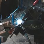 man welding a black metal